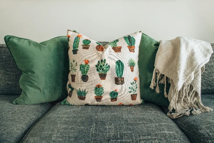 A DIY pillow with many green cactus patterns.