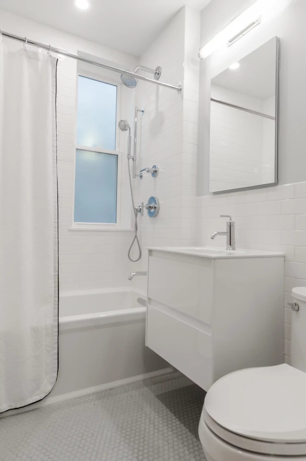 A white bathroom with a shower curtain, whose hooks slide smoothly.