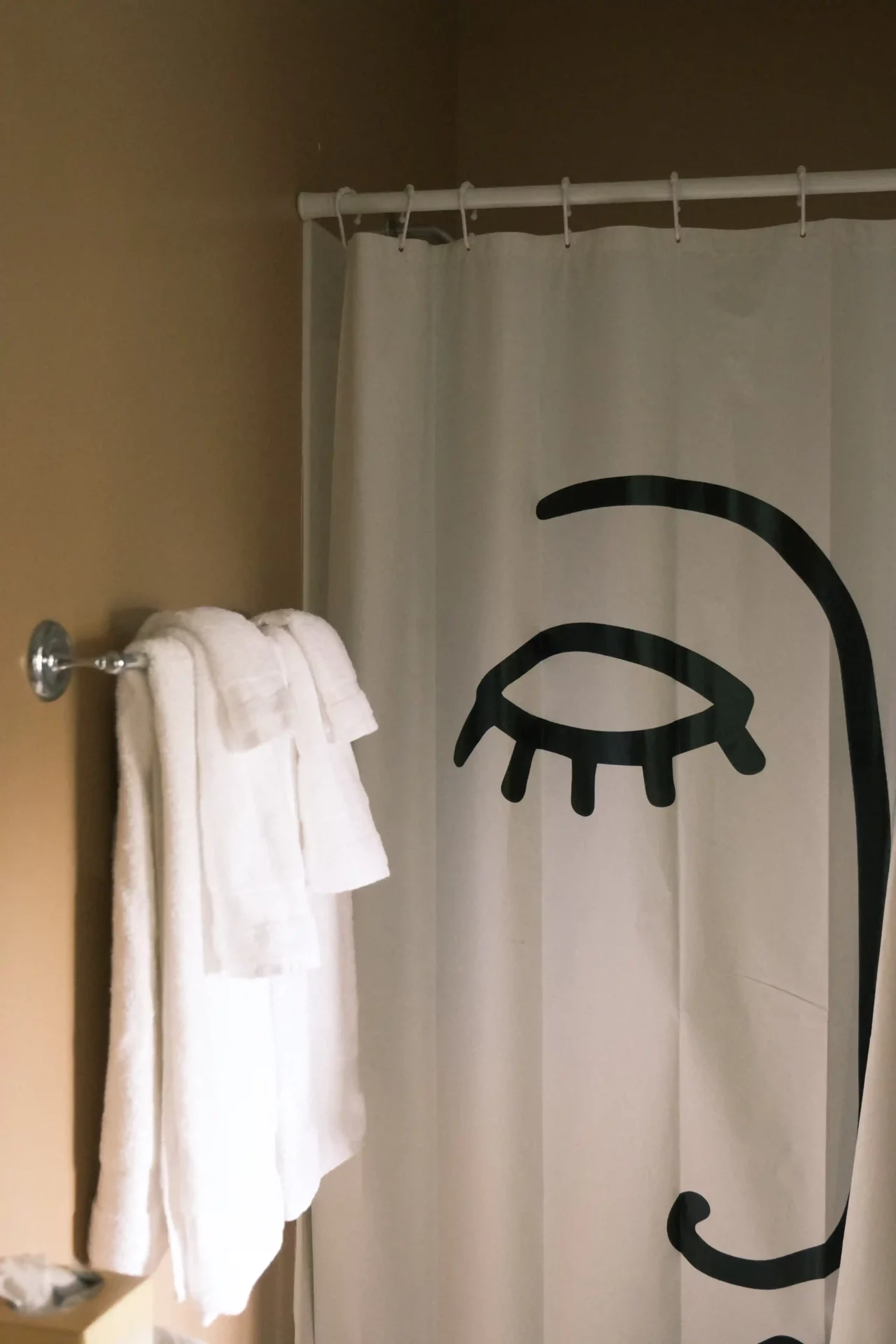 A bathroom with a shower curtain in an abstract style, whose hooks slide smoothly.