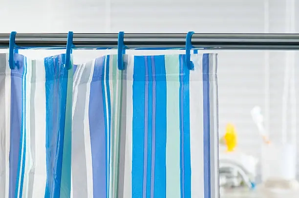 Change your shower curtain to a blue and white striped curtain hanging on a rod.